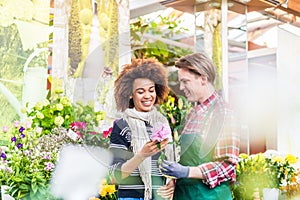 Cheerful female customer buying flowers at the advice of a helpful vendor