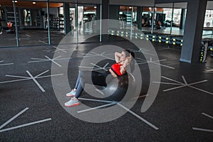 Cheerful female doing abdominal crunches on exercise ball