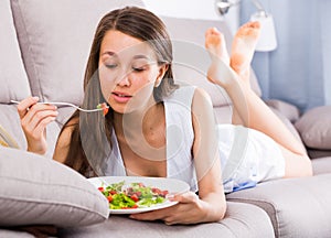 Cheerful female is enjoying tasty green salad