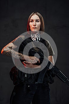 Cheerful female mercenary with assault rifle in dark background