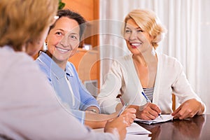 Cheerful female pensioners making list