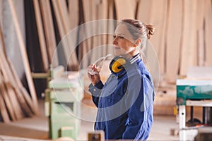 Cheerful female production operator in blue coverall
