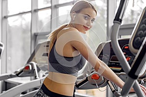 Cheerful female running in fitness center