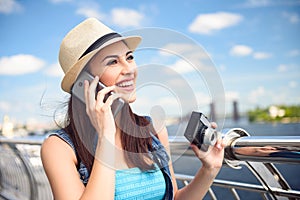 Cheerful female tourist communicating on telephone