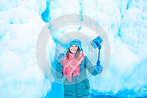 Cheerful female wonderer waves hand and talking via smartphone during video call