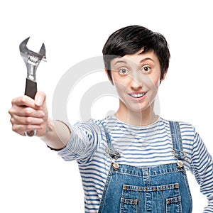 Cheerful female worker holding wrench