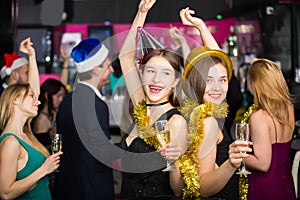 Cheerful females and males celebrating new year