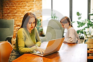 Cheerful freelancer using laptop in cafe