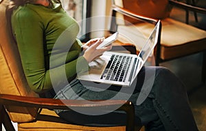 Cheerful freelancer using laptop in cafe