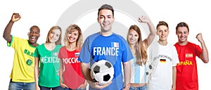 Cheerful french soccer fan with ball and fans from other countries