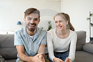 Cheerful young couple bloggers looking laughing at camera at home photo