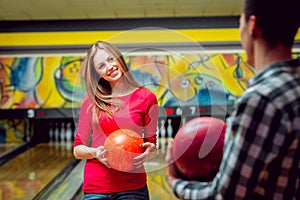 Cheerful friends at the bowling alley with the balls.