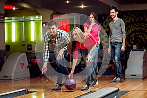 Cheerful friends at the bowling alley with the balls.