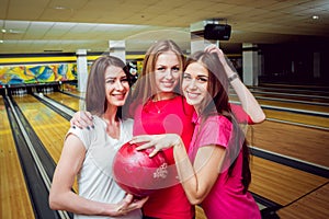 Cheerful friends at the bowling alley with the balls.