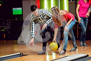 Cheerful friends at the bowling alley with the balls.