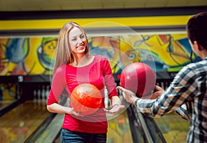 Cheerful friends at the bowling alley with the balls.