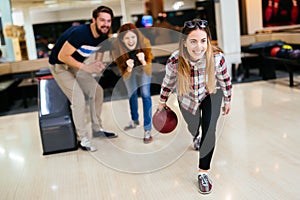 Cheerful friends bowling together and having fun