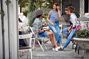 Cheerful friends chatting at the bar`s backyard. Quality friendship time together