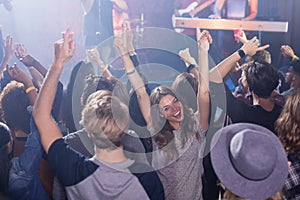 Cheerful friends dancing in nightclub