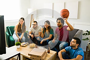 Cheerful friends hanging out to watch the basketball game