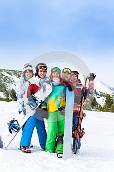 Cheerful friends standing with snowboards