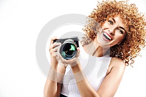 Cheerful frizzy-haired lady holding a digital camera
