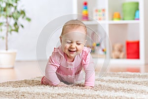 Cheerful funny baby crawling indoors at home