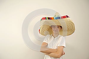 Cheerful and funny boy with a Mexican sambrero on a yellow background photo
