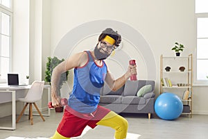 Cheerful funny man making fitness training with dumbbels at home
