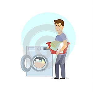 Cheerful funny man washing clothes laundry in washing machine