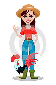 Cheerful gardener woman rancher showing ok sign and standing near rooster.