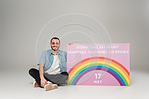 Cheerful gay man near placard with