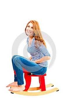 Cheerful girl in baby rocking chair in the studio