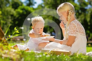 Cheerful girl and boy eating sweets in the park