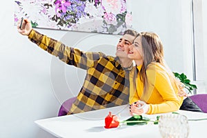 Cheerful girl and boy testing new phone front camera, making selfie.