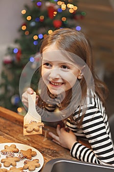 Cheerful girl cooking sweet cookies in the kitchen