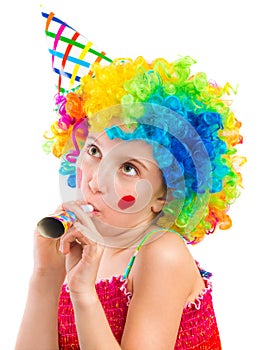 Cheerful girl in curly clown wig and party horn blower