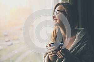 Cheerful girl drinking coffee or tea