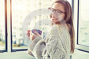 Cheerful girl drinking coffee or tea