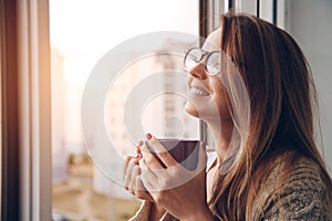 Cheerful girl drinking coffee or tea