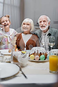 cheerful girl with grandparents near easter