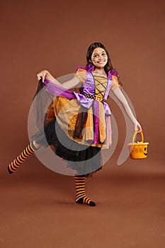 cheerful girl in Halloween costume holding