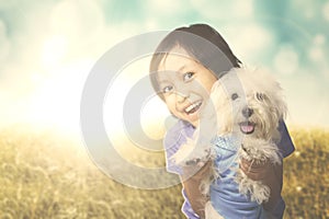 Cheerful girl hugging a Maltese dog