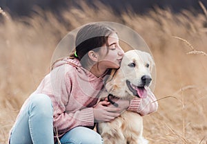 Cheerful girl kissing lovely dog