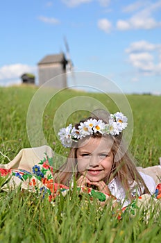 Cheerful girl laying on the blanket in the field