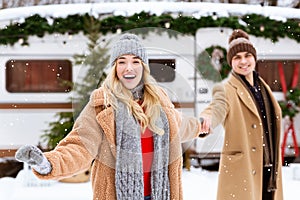 Cheerful Girl Leading Her Boyfriend To Watch Snowfall Outdoors On Winter Day photo
