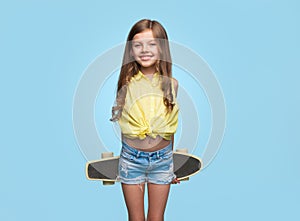 Cheerful girl with longboard on blue