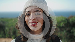 Cheerful girl looking camera on windy day closeup. Happy young traveler resting