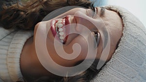 Cheerful girl looking camera on windy day vertical closeup. Happy young traveler