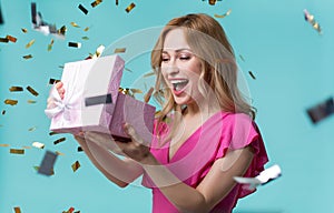 Cheerful girl opening gift box with interest